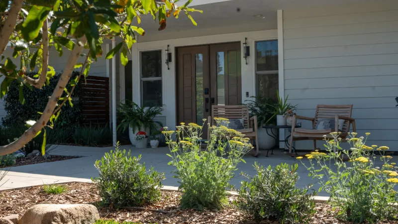 Beautiful outdoor patio with plants, seating, and a welcoming entrance to a modern home.