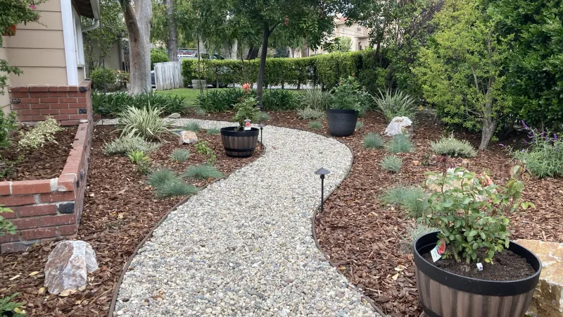 Meandering, lighted garden pathway provides purpose for this side yard
