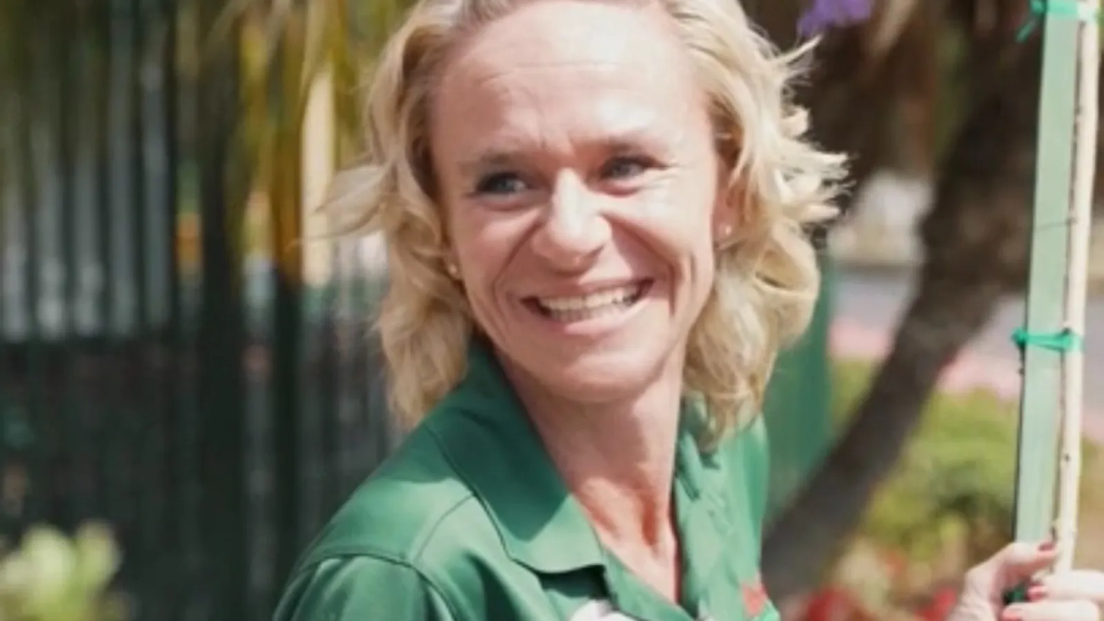 a woman smiling and holding a pole