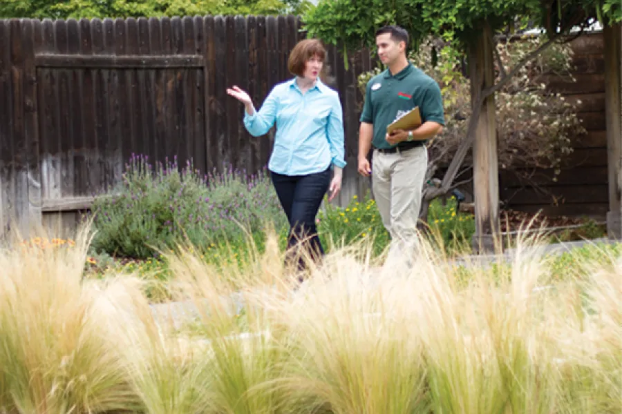 Armstrong landscape designer walking a garden with a customer