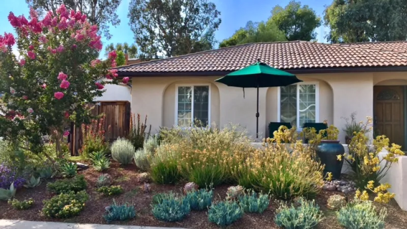 A colorful umbrella adds a nice design element to this front garden remake