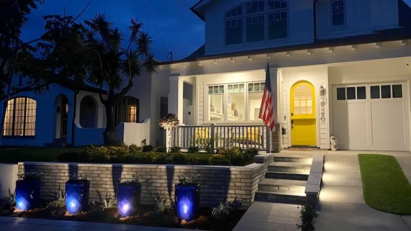 Accent lighting dramatically highlights the blue pots in this San Diego front landscape design