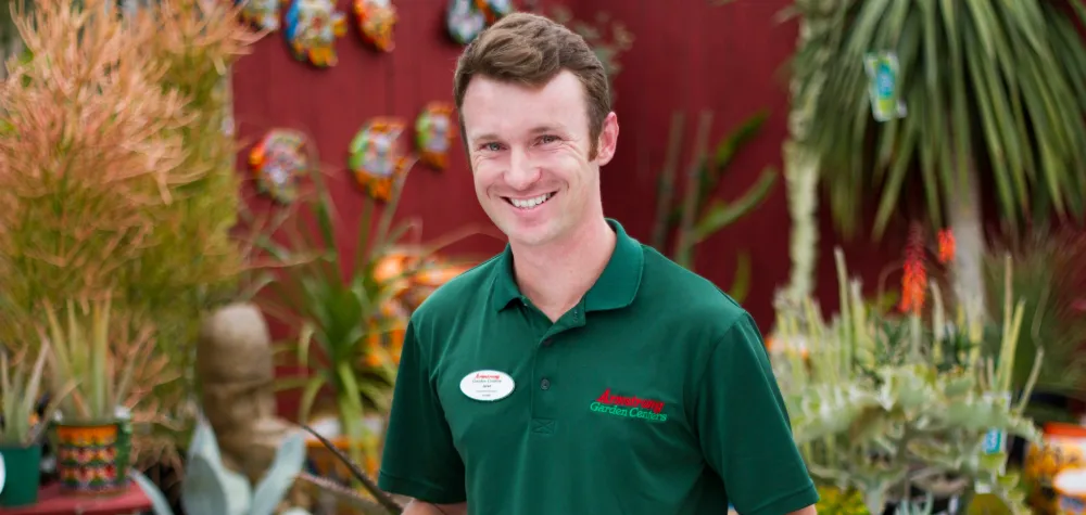 a man standing in front of a plant